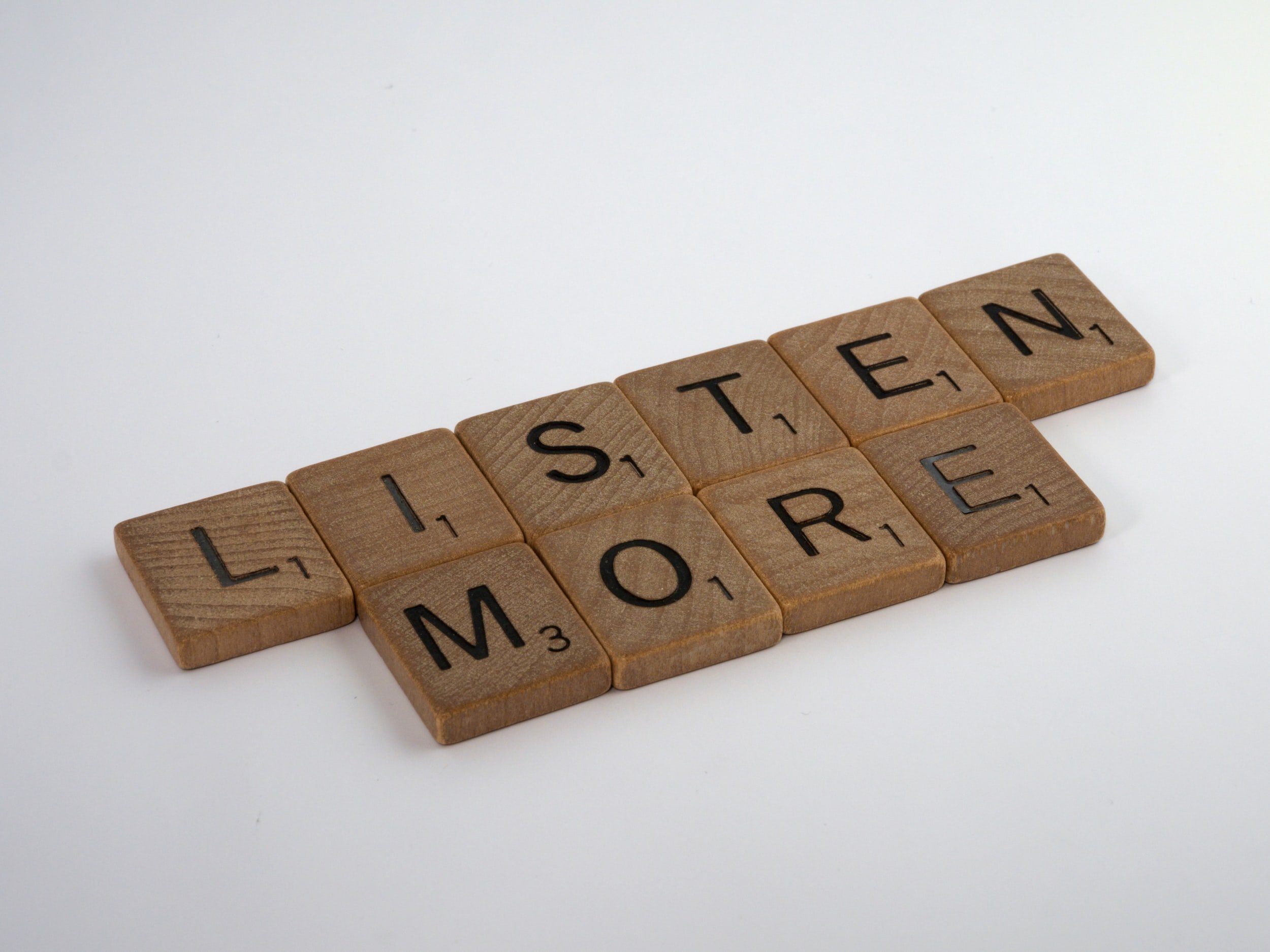 "Listen more" is written in wooden letter tiles.