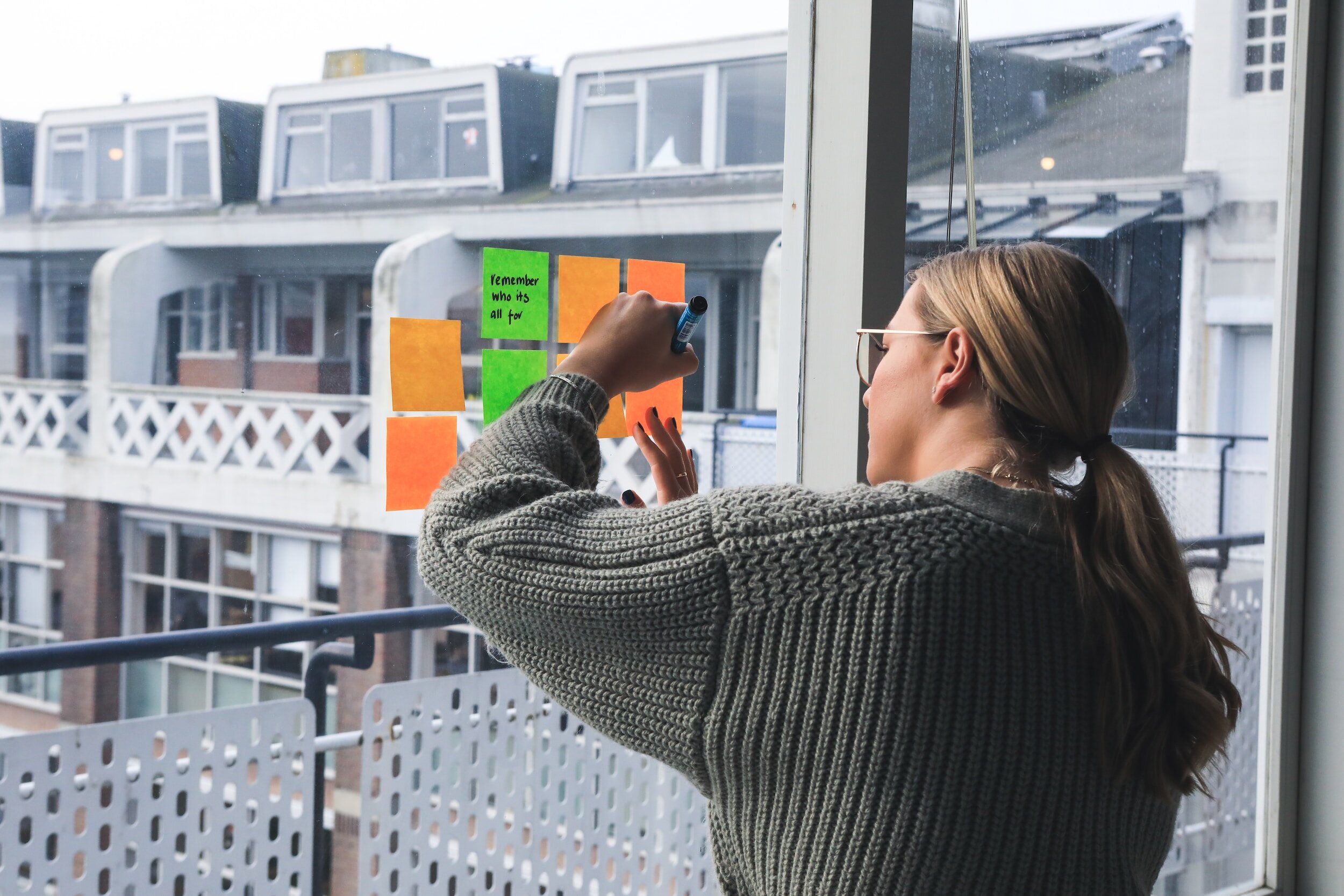 With colourful post-it notes stuck to the window, a woman begins to generate ideas.