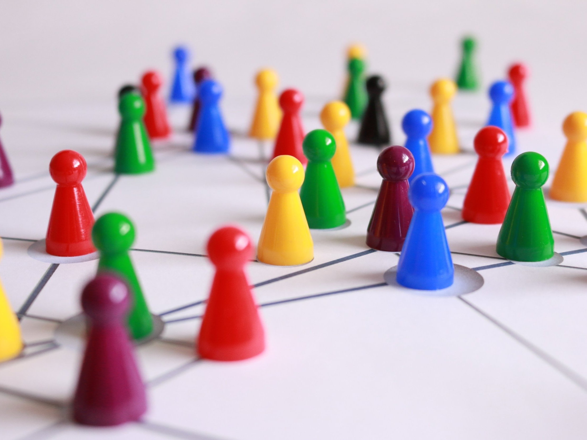 Networking is demonstrated with yellow, green, red, and brown plastic cones on a white-lined table.
