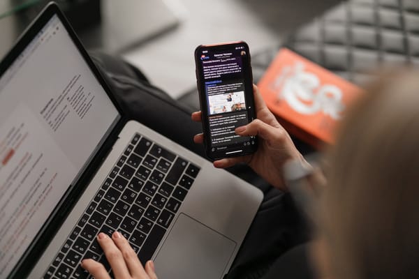 Person reviewing email strategies on laptop and phone for successful freelancer newsletters.